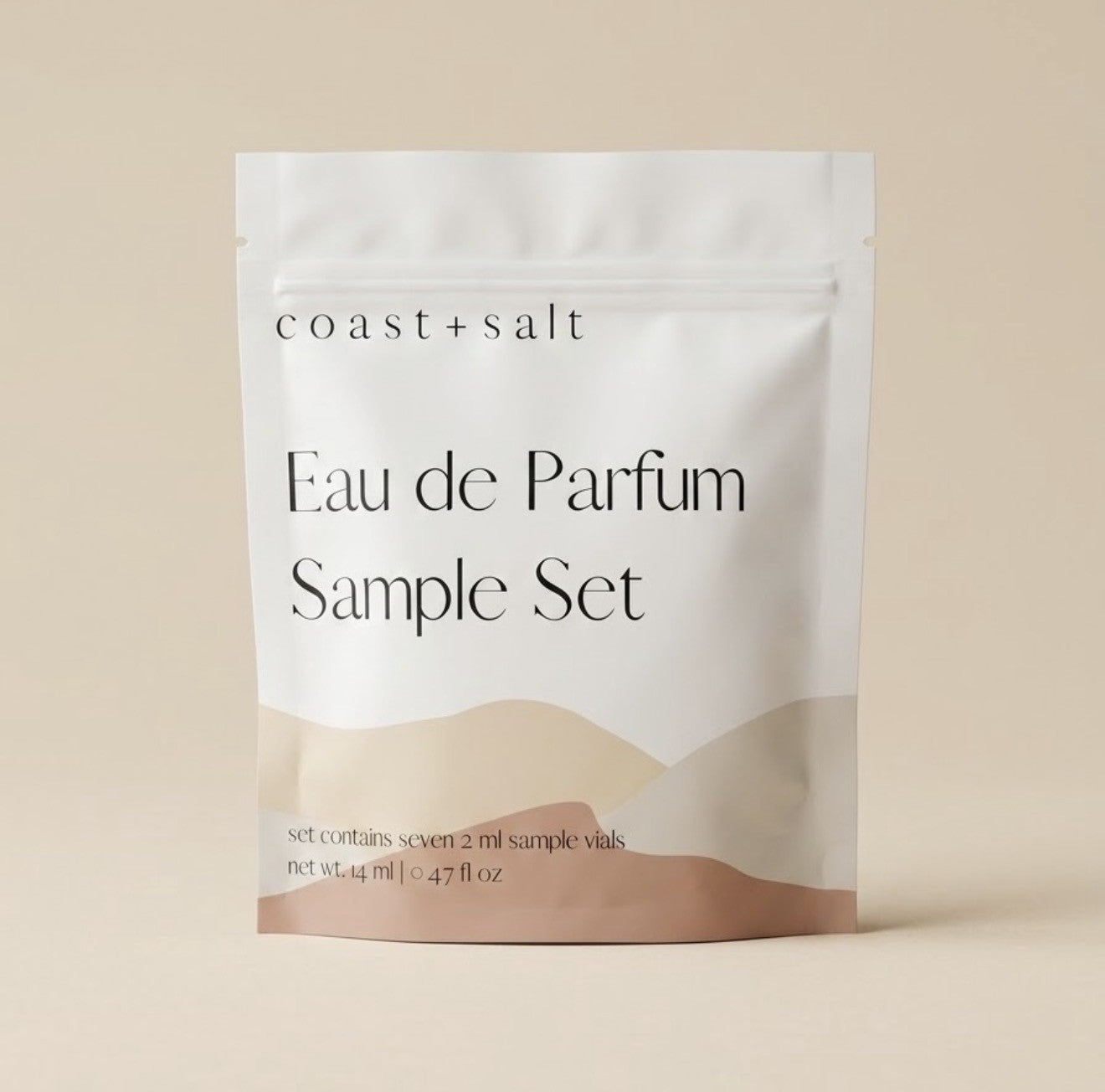 A stand-up pouch package labeled 'coast + salt' and 'Eau de Parfum Sample Set' on a warm beige background.