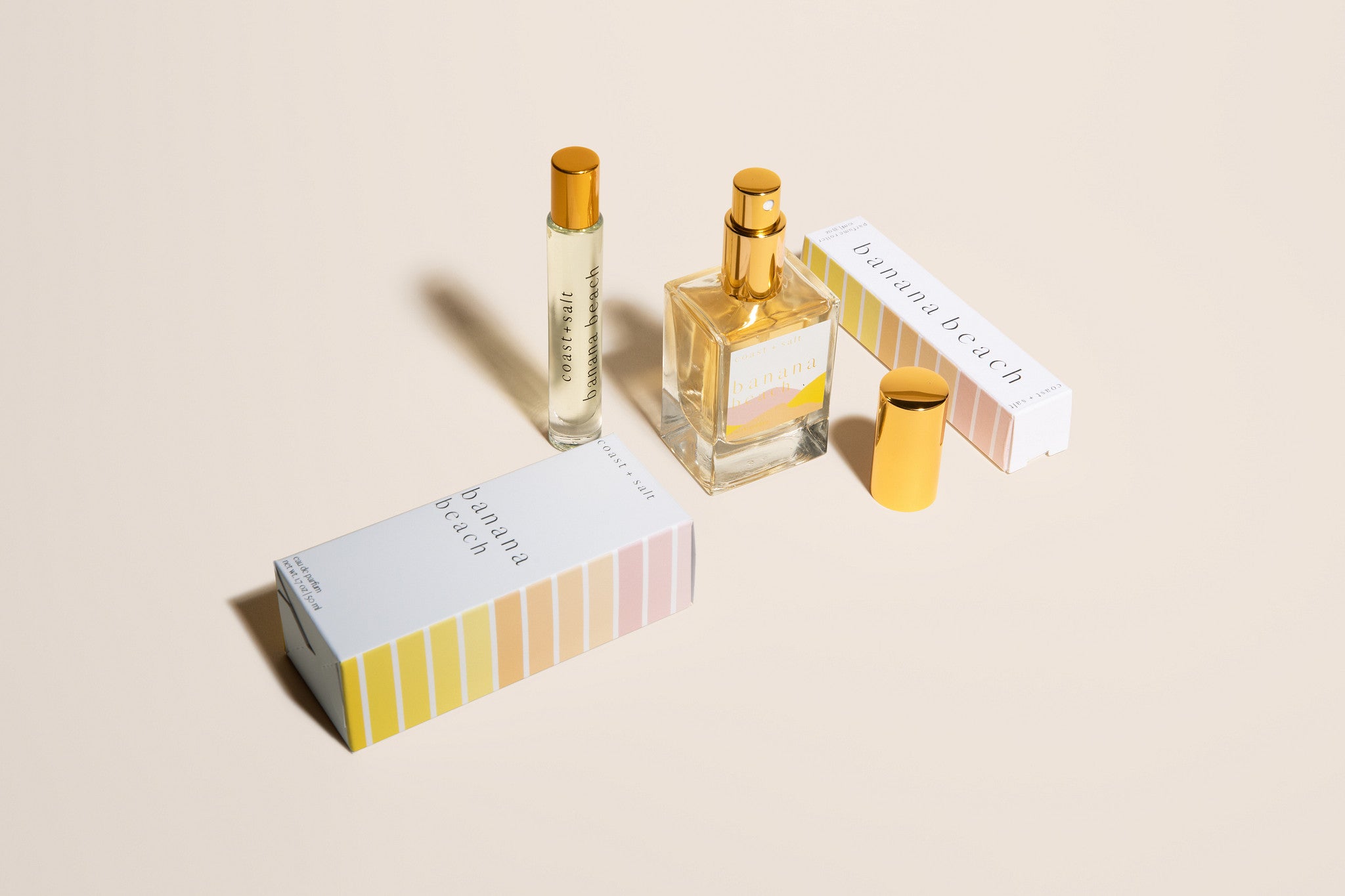 Two perfume bottles with their packaging on a beige background