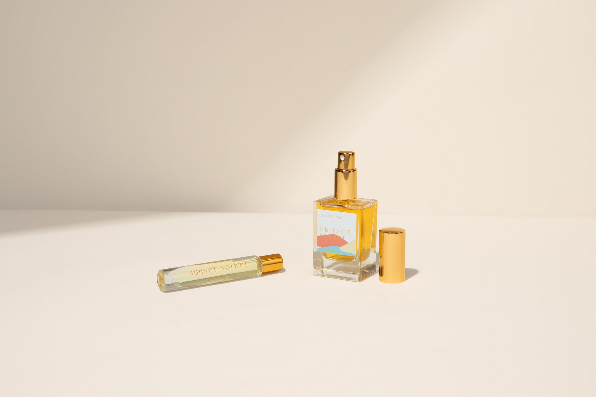 Sunset Sorbet Perfume bottle and rollerball on a beige background